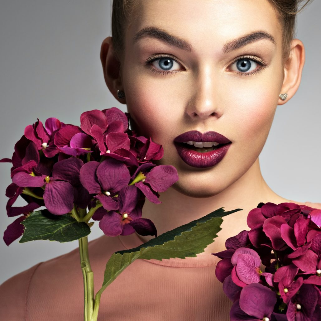Girl with a creative hairstyle purple flowers.