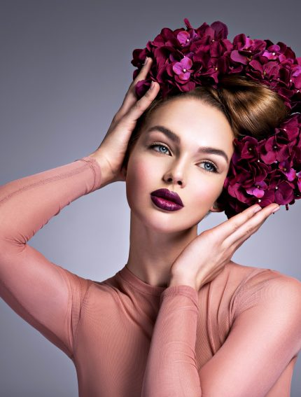 Young woman with a bouquet of purple flowers in her hair. Young woman with a bouquet of purple flowers in her hair.